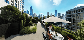 people sitting at tables on a roof terrace with a view of the city at Chateau on Wells, Chicago, Illinois
